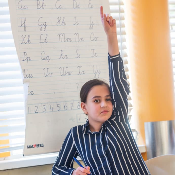 Een leerling die haar hand opsteekt